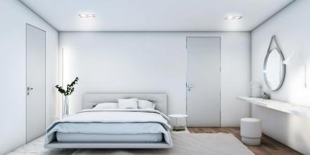 master bedroom of modern apartment with desk mirror and bed